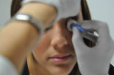 While the upper and lower lids are still pulled away, the top side of the prosthesis is replaced in the eye socket