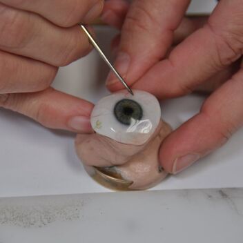 Photo of a green eye prosthesis being hand painted