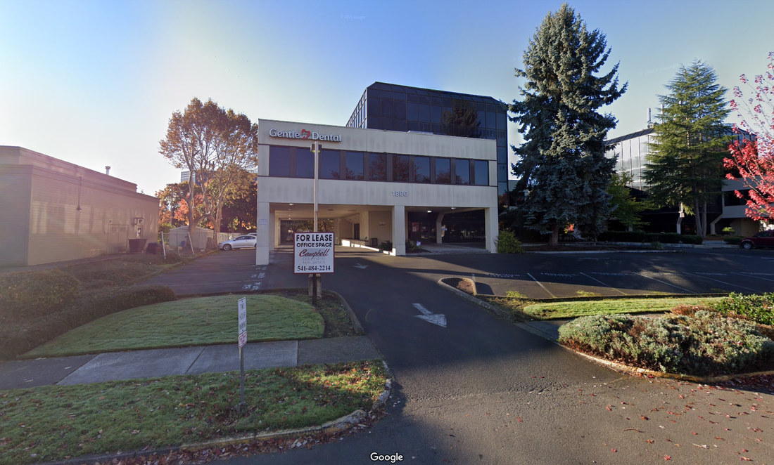 A Google Street photo of the clinic office in Eugene. The building is beige with black glass windows and a large sign that says Gentle Dental on the front.